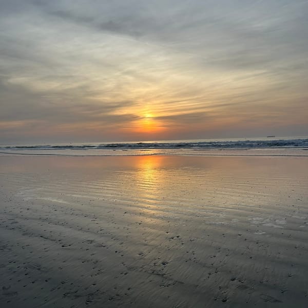 A sunrise on the ocean with orange, blue, and gray tones